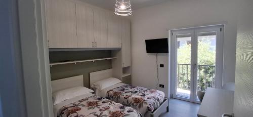 a room with two beds and a door with a window at A casa di Nonna Peppina a Caggiano in Caggiano