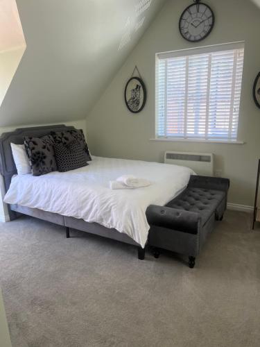 a bedroom with a bed and a chair and clocks at Loft Studio in Davenham