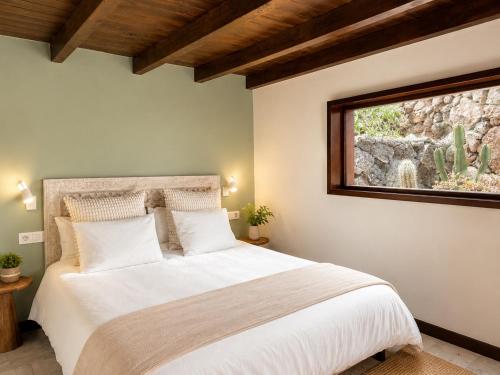 a bedroom with a large white bed with a window at Villa Blanco - Romantic Hideaway - Private Villa for Couple in Tías