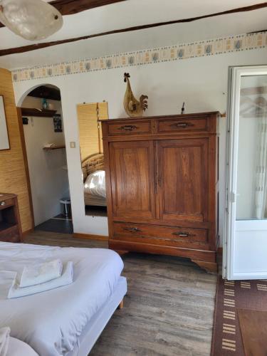 a bedroom with a wooden dresser and a mirror at Gîte de l'Escoutal La Vallée in Le Bleymard