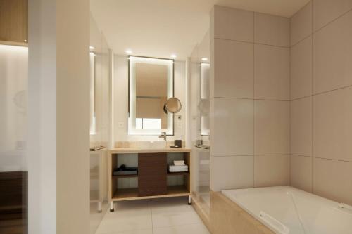 a white bathroom with a sink and a mirror at Courtyard by Marriott Manado in Manado