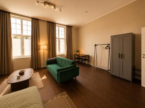 a living room with a green couch and a table at Schängel Chic 03 in Koblenz