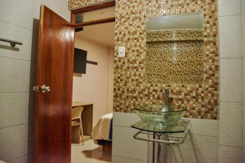 a bathroom with a glass bowl on a glass table at QAIPU HOTEL in Puquio