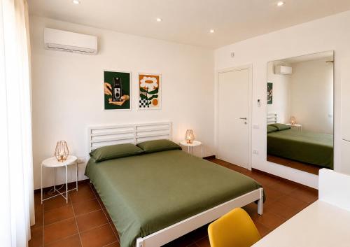 a bedroom with two green beds and a yellow chair at GV Apartments in Caserta