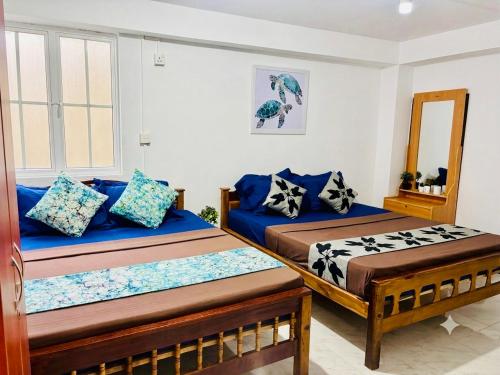 a room with two beds and a mirror at The Beach House , Nilaveli , Trincomalee in Trincomalee