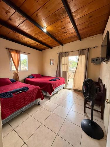 two beds in a room with wooden ceilings at Cristales de Antigua Casa Cristal in Antigua Guatemala