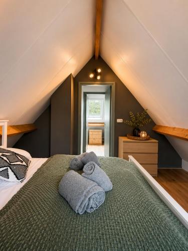 a bedroom with a bed with towels on it at Ecolodges De Dreef Guesthouse in Renesse