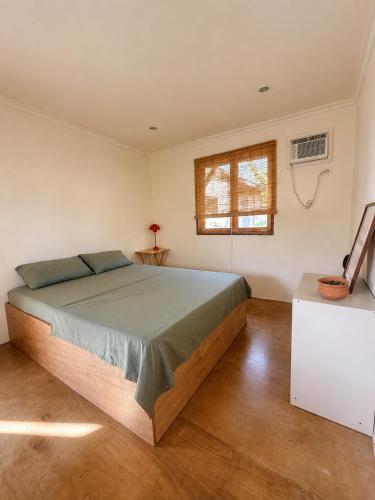 a bedroom with a large bed and a window at Surfer's Hideout - central two-storey HOUSE with garden & private balcony in General Luna