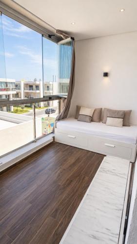 a bed in a room with a large window at Le Ramo - Résidence Ramoflores in Sidi Rahal