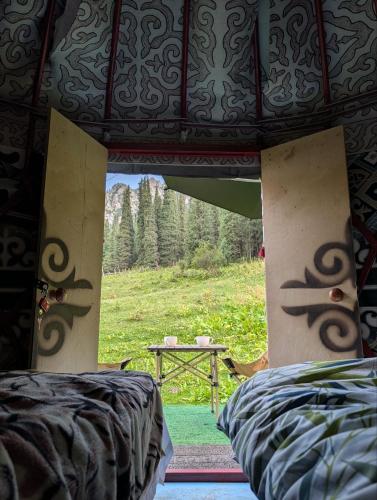 a room with two beds and a view of a table at Altyn Sky in Mineralʼnyy Istochnik Altyn-Arasan