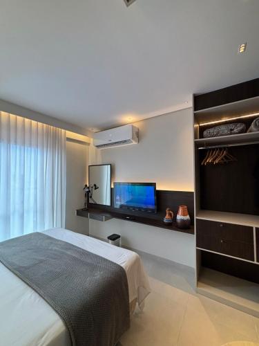 a bedroom with a bed and a flat screen tv at Studio Luxuoso com vista surpreendente in Macapá