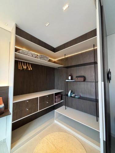 a walk in closet with dark wood paneling at Studio Luxuoso com vista surpreendente in Macapá