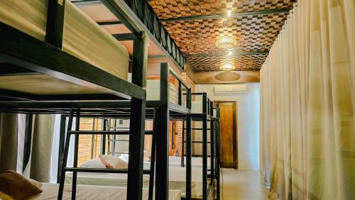 a hallway with bunk beds in a room with a ceiling at Dayunan in Bacolod