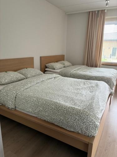 two twin beds in a bedroom with a window at Helsinki Airport Apartment Stay in Vantaa
