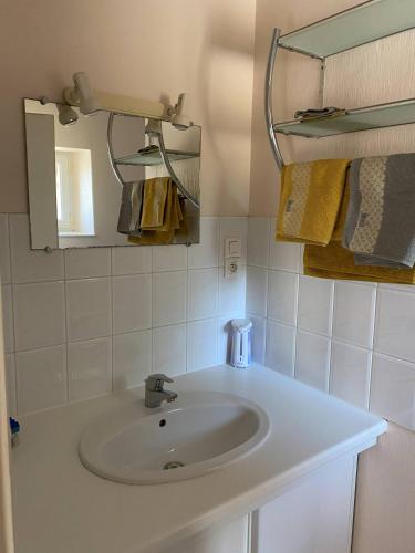 a bathroom with a sink and a mirror and towels at Meublé chocolat in Réaumur