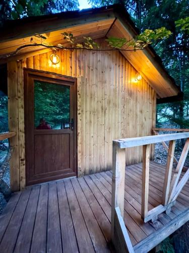 a cabin with a door on a wooden deck at Flori's House in Valbonë