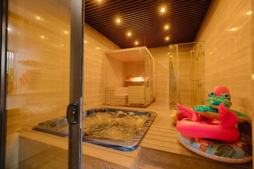 a bathroom with a tub and a shower with a toy at Biệt Thự FLC Sầm Sơn 7PN VIP BT43-02 in Sầm Sơn