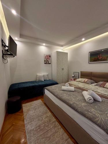 a hotel room with two beds and a television at APARTMAN BAMBUS in Lug