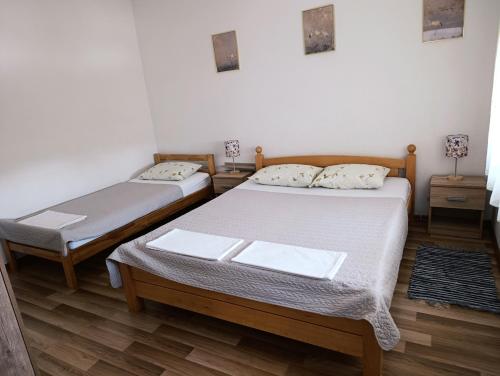 two twin beds in a room with wooden floors at Apartman Vila Vita in Čapljina
