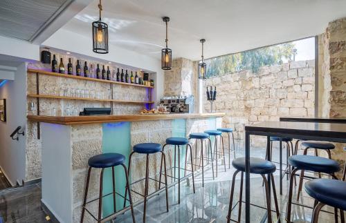 un bar con sgabelli blu in un ristorante di Heleni Hotel a Gerusalemme