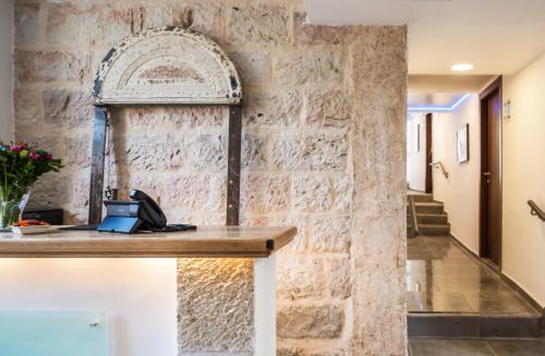 a stone wall in a hallway with a desk at Olive Heleni Hotel in Jerusalem