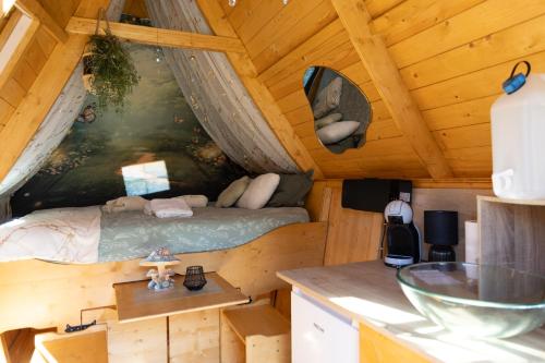 a bedroom in a log cabin with a bed in it at La cabane féerique in Ames