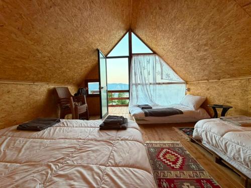 a bedroom with two beds in a room with a window at Strofka in Maliq