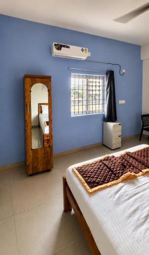 a blue room with a bed and a mirror at Hotel Far-Inn in Irungattukottai