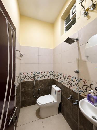 a bathroom with a toilet and a sink at Hotel Far-Inn in Irungattukottai