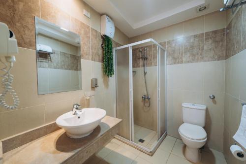 a bathroom with a toilet and a shower and a sink at Fantasia Hotel in Hurghada