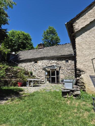 a stone building with a picnic table in front of it at Gîte de l'Escoutal La Vallée in Le Bleymard