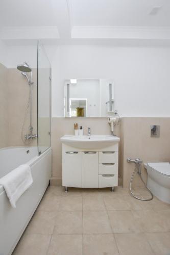 a bathroom with a sink and a tub and a toilet at Hotel Astoria, в самом центре города in Astana