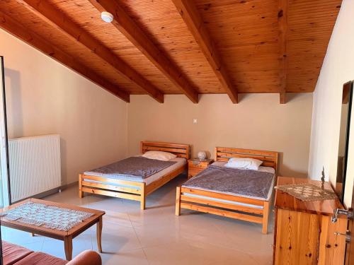 a bedroom with two beds and a wooden ceiling at Sonya Apartments in Mesochórion