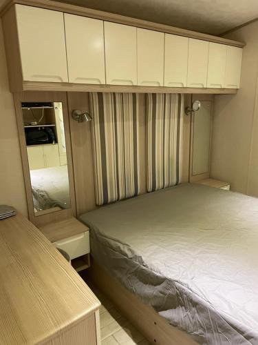 a small bedroom with a bed and a mirror at Mon nid douillet in Valras-Plage
