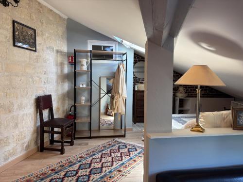 a room with a bed and a lamp and a chair at Grange d'époque à Chantilly in Chantilly