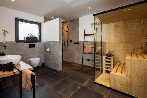 a bathroom with a shower and a toilet and a sink at Haus Vogl Anger - Ferienwohnungen mit privater Sauna und beheizten Salzwasser Pool in Panoramalage und Nähe zu Salzburg und Berchtesgaden in Anger