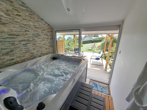 eine große Badewanne in einem Zimmer mit Terrasse in der Unterkunft Adorelys séjour bien être - spa et massage in Saint-Cassien