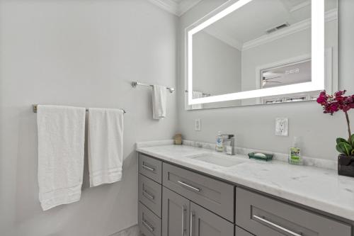 a bathroom with a sink and a mirror and towels at National Harbor Suite 2 in Fort Washington