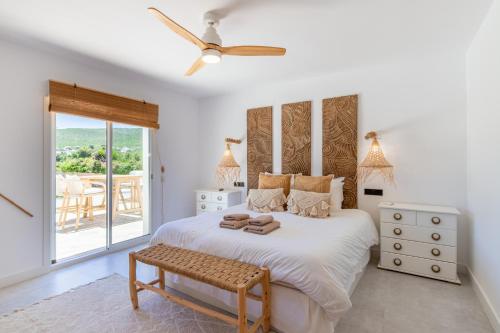 a bedroom with a bed with a ceiling fan at Casa Lou Lou JAVEA in Benitachell