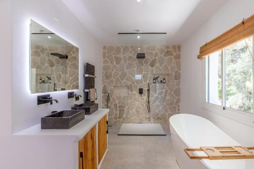 a bathroom with a tub and a sink and a shower at Casa Lou Lou JAVEA in Benitachell