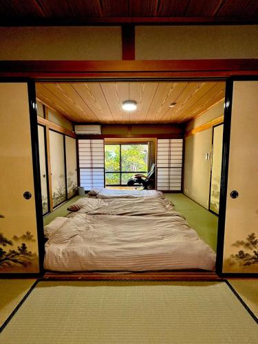 a large bed in a room with a window at Guest House Masaru ゲストハウス勝 in Nagano