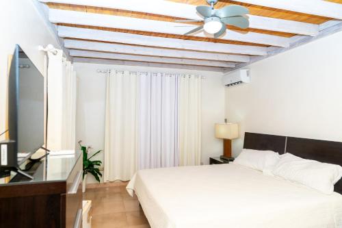 a bedroom with a white bed and a ceiling fan at casa maria in La Romana