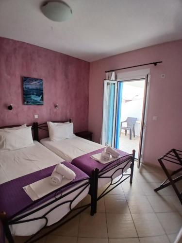 a hotel room with two beds and a balcony at Studio nikolos in Elafonisos