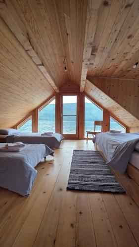 a large room with two beds and a large window at Splav Zaliv, Perućac in Aluga