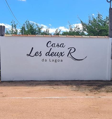 a white wall with a sign that reads casa las delezrosra at CASA Les Deux R da Lagoa in Jijoca de Jericoacoara