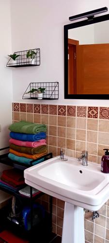 a bathroom with a sink and a mirror and towels at Casa Yahshua in Villaverde