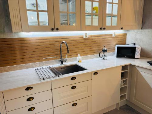 eine Küche mit Spüle und Mikrowelle in der Unterkunft Studioflat in centrum in Stavanger
