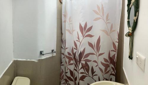 ein Badezimmer mit Toilette und Duschvorhang in der Unterkunft Great Hostels Amazon in Puyo