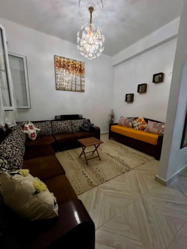 ein Wohnzimmer mit Sofa und Kronleuchter in der Unterkunft Ariam in Annaba