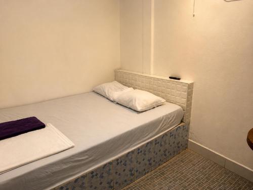 a small room with a bed with white sheets at EL Viajero ll in Estelí